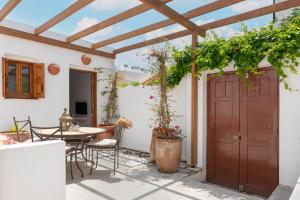 Un patio con una puerta de madera y una mesa y sillas. en Villa Vasoula Lindos, Jasmine and Gardenia Suite, en Lindos
