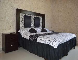 a bedroom with a large bed and a night stand at Hotel Guadalupe Bernal, Peña de Bernal in Bernal