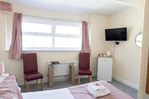 een slaapkamer met een tafel en 2 stoelen en een raam bij Carlton House Scarborough in Scarborough +78 foto's