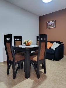 a dining room with a table and chairs with a couch at Hospedaje Las Rosas in La Quiaca
