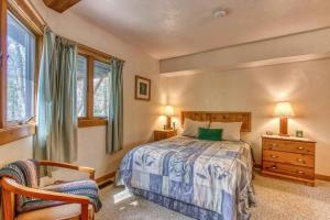 een slaapkamer met een bed, een stoel en ramen bij Woods Child Cabin By Beyond Expectation W Hot Tub in Gatlinburg +37 foto's