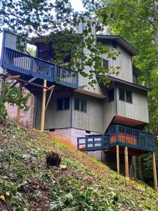 een groot huis met een blauw terras op een heuvel bij Woods Child Cabin By Beyond Expectation W Hot Tub in Gatlinburg