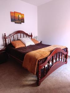 a bedroom with a large wooden bed in a room at Hospedaje Las Rosas in La Quiaca +5 photos