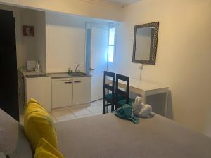 a bedroom with a bed and a desk and a kitchen at Eco Dpto Estudio El golf 9 in Santiago