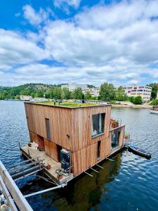 a house on a dock on a body of water at One of the kind Prague Houseboat Experience +BOAT in Prague