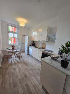 a kitchen with white cabinets and a table and a dining room at Stilvoll zu Hause mit Charme, bis zu 6 Personen in Halberstadt