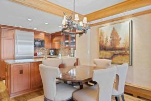 a dining room with a wooden table and white chairs at Lodge Tower 694 One Bedroom Residence in Vail