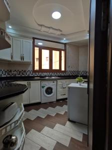 a kitchen with white cabinets and a washing machine at Passo Nador 3 chambres in Nador +12 photos