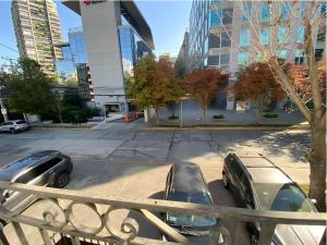 two cars parked in a parking lot in a city at Eco Dpto Estudio El golf 9 in Santiago +2 photos