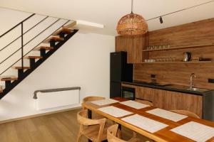 a kitchen and dining room with a table and a staircase at Northstar Villas in Bogë
