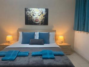 a bedroom with a bed with blue pillows on it at Cheerful holiday two bedrooms flat with BBQ in Msida