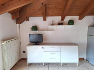a kitchen with a white desk with a tv on it at Family Stop Tirano in Tirano +6 photos