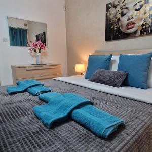 a bedroom with two blue towels on a bed at Cheerful holiday two bedrooms flat with BBQ in Msida +22 photos
