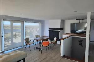 エル・カラファテにあるLuxury Villa en El Calafate, Argentinaのテーブルと椅子とテレビのあるリビングルーム