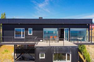 エル・カラファテにあるLuxury Villa en El Calafate, Argentinaのデッキとバルコニー付きのブラックハウス