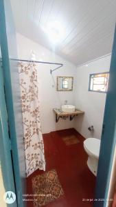 a bathroom with a toilet and a sink at Casa de temporada 3 quartos in São Bento do Sapucaí