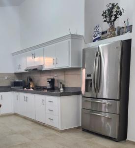 a kitchen with a stainless steel refrigerator and white cabinets at KERY-OASIS 2bdr with pool close to the Beach in Las Terrenas +24 photos