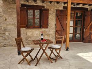a table with a bottle of wine and two chairs at Katerinas Sweet Place studio 1 in Tsadha