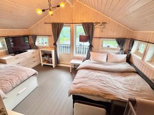 a bedroom with two beds and a television in it at Riverfront house with 98 inch TV, ps5 & activities in Narvik