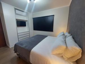 a bedroom with a large bed and a flat screen tv at Apartamento Luxuoso decorado e mobiliado in Ribeirão Preto +21 photos