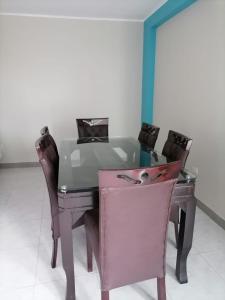 a dining room table with chairs and a pink desk at Departamento cómodo para una estancia feliz in Ayacucho
