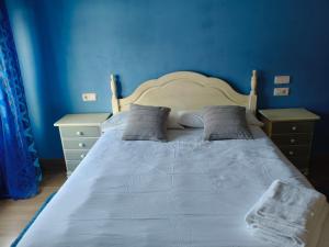 a blue bedroom with a white bed with two night stands at Monica in Altamira