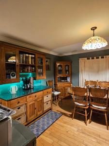 a kitchen with wooden cabinets and a table and chairs at The Plough B&B in Ventry