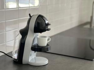 a coffee maker sitting on a counter with a cup at Casa Ventuno in Civitavecchia