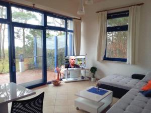 un salon avec un canapé et une télévision dans l'établissement Fewo Wellenblick Trassenheide Usedom, à Trassenheide