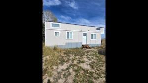 a large white building on the side of a field at Rate Drop! Enjoy the Simplicity-Teton Tiny House L in Tetonia