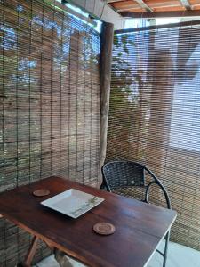 a wooden table with a laptop on top of it at Boipeba Apartamento TERRA com varanda e cozinha ao ar livre in Cayru