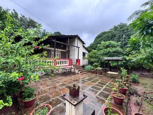 a house with potted plants in front of it at The 1970 - Rajgad in Welhe