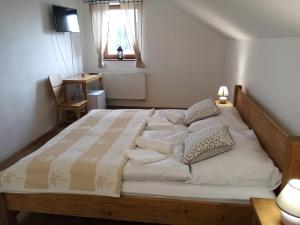 un grande letto bianco in una camera da letto con finestra di Penzion Toliar a Vrbov