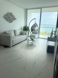 ein weißes Wohnzimmer mit einem Sofa und einem Stuhl in der Unterkunft Apto de Ensueño Frente al Mar in Playa Bello Horizonte