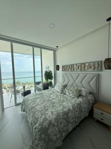 ein Schlafzimmer mit einem Bett mit Blick auf das Meer in der Unterkunft Apto de Ensueño Frente al Mar in Playa Bello Horizonte
