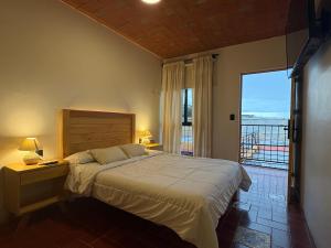 a bedroom with a large bed and a balcony at Casa Agaves Conjunto Habitacional in Oaxaca City