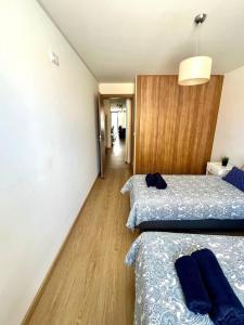 a bedroom with two beds and a hallway at Casa Ponte do Mar in Sines