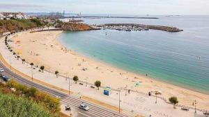 a beach with people on the sand and the water at Casa Ponte do Mar in Sines