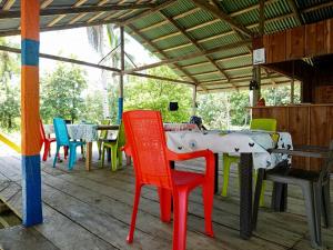 a table with colorful chairs on a patio at Cabaña y restaurante vikana in Nuquí