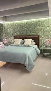 een slaapkamer met een bed met een groene deken en 2 lampen bij estudio de lujo 1709 in Cartagena