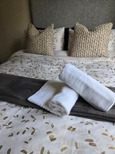 a bed with towels and pillows on it at Scott Sandton Apartments & Cozy Escapes in Sandton +20 photos