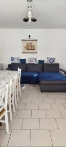 a living room with a blue couch and a table at Maison spacieuse près de Marennes-Hiers-Brouage (90 m²) in Marennes