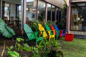 a row of colorful chairs in front of a building at Poas Volcano Lodge in Vara Blanca