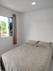 Un dormitorio blanco con una cama y una ventana. en Pousada Tendawa, en Santarém