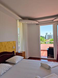 ウルツィニにあるCentro apartments and roomsのベッドと大きな窓のある寝室