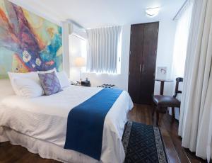 贾拉普Colombe Hotel Boutique的卧室里有一张床，墙上挂着一幅画