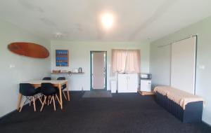 a bedroom with a bed and a table and chairs at The green Room in Mangawhai