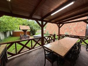 a patio with wooden tables and chairs on a wooden deck at Sayat Nova Home in Dilijan
