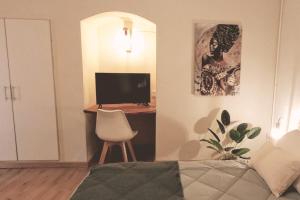 a bedroom with a desk with a television and a chair at ORIGEN Centro Monoambiente in El Bolsón
