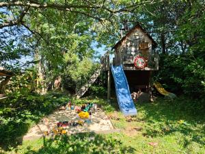a play yard with a play house and a slide at Farma na Lazoch in Slatinské Lazy